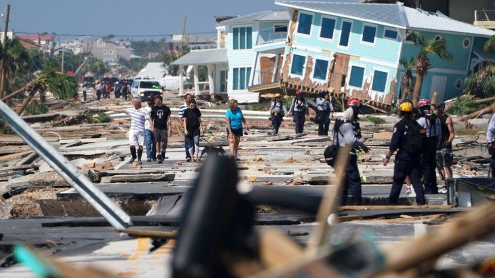 Mexico Beach residents walk down a street on Thursday