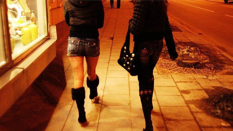 Women walking along a street at night