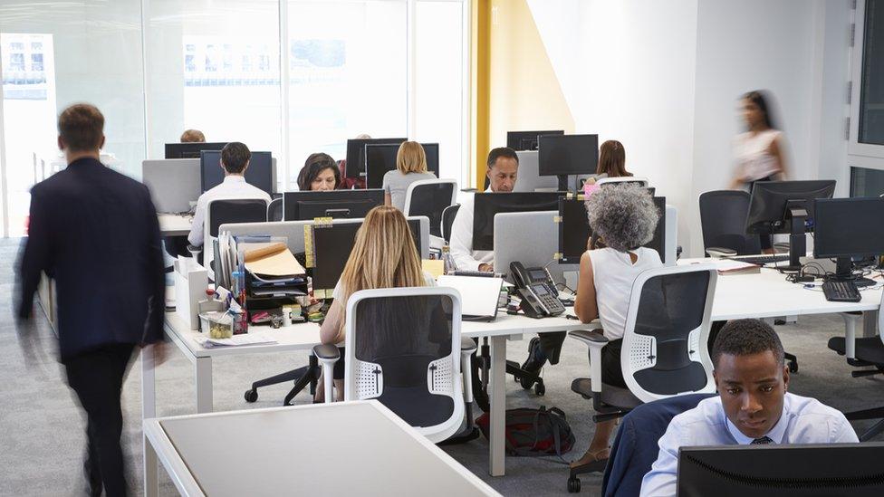 Man walking through a busy open plan office