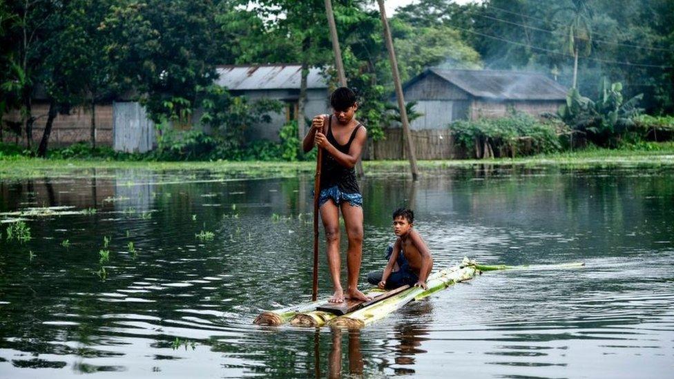 Indian children paddle a raft through floodwaters at Kalgachia in Barpeta district in India's northeastern state of Assam, on July 12, 2019.