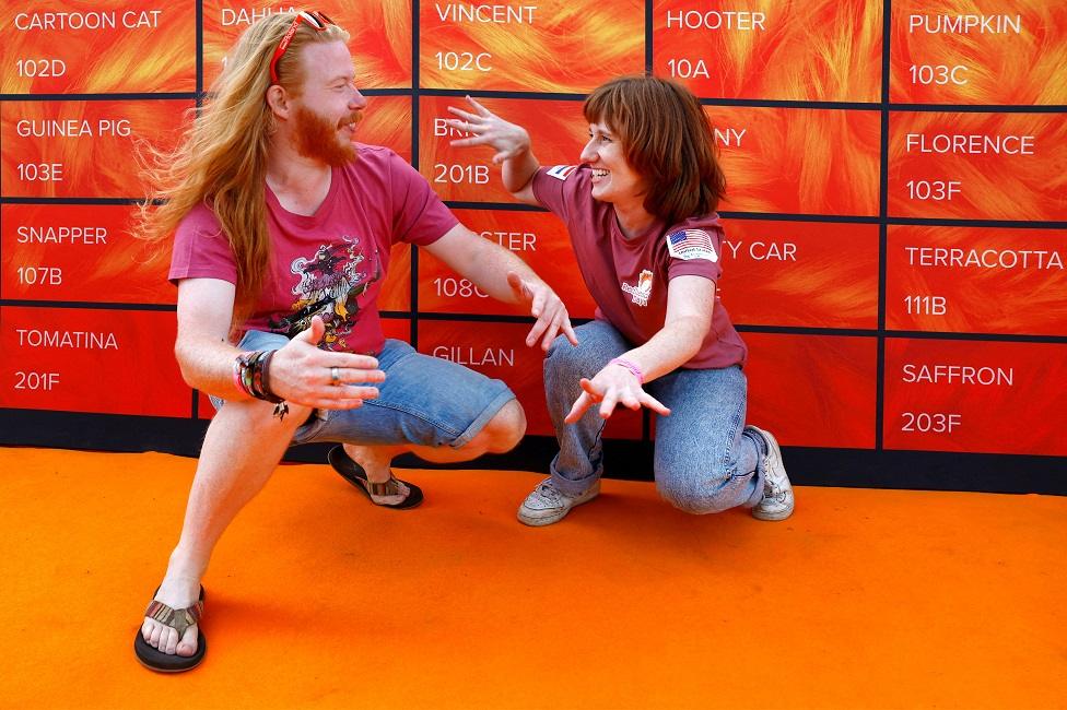 Marc, 34, from Limburg area, and Rhen, 30, from Rotterdam (originally from US) pose in front of a wall showing different hair colours