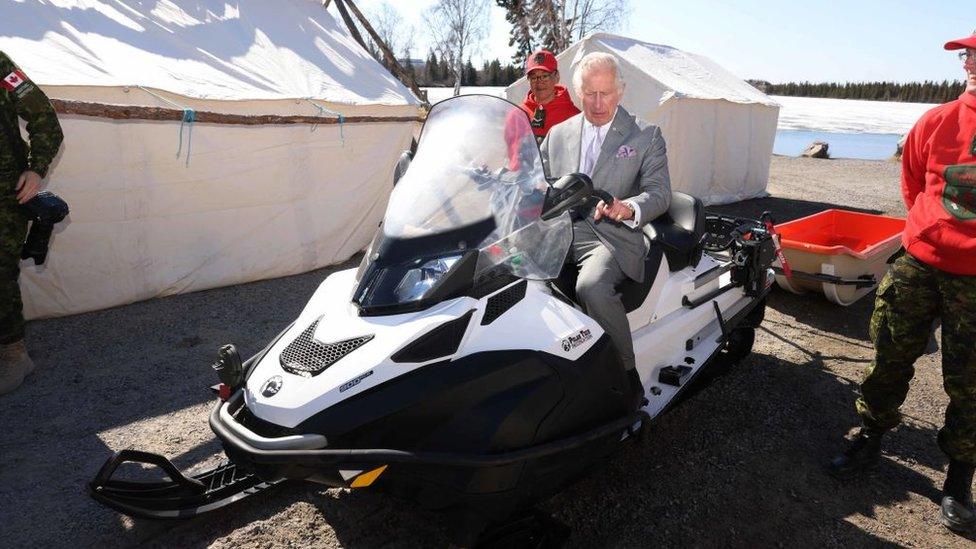 Prince Charles sits astride a snow mobile