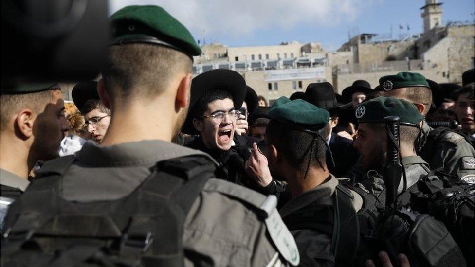 Israeli border police scuffle with ultra-Orthodox Jews protesting against members of the "Women of the Wall" feminist organization gathering inside the women's section of the Western Wall in Jerusalem's Old City, 8 March 2019