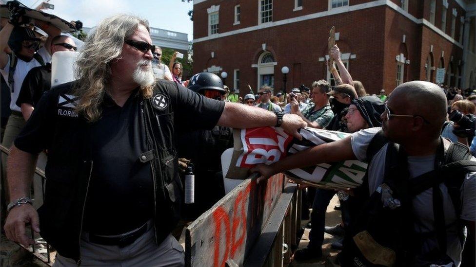 A white supremacist grabs a counter protesters" sign during a rally in Charlottesville, Virginia, U.S.