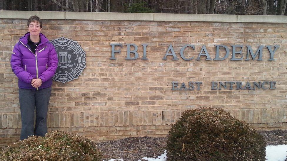 Nicky Perfect by a sign that says FBI Academy