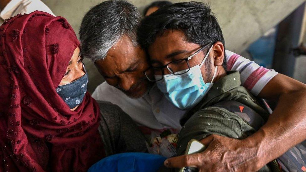 A man embraces his son who was evacuated from Ukraine after his arrival on a special flight at the airport in Chennai on February 27, 2022.