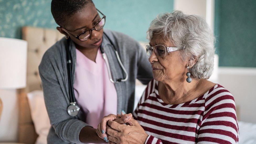 Carer helping woman with Alzheimer's