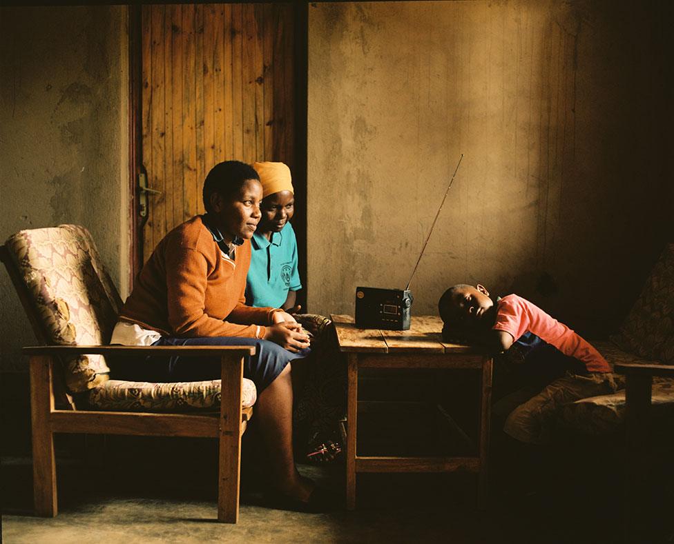 Solonge with her bother and brother listen to a read in their home