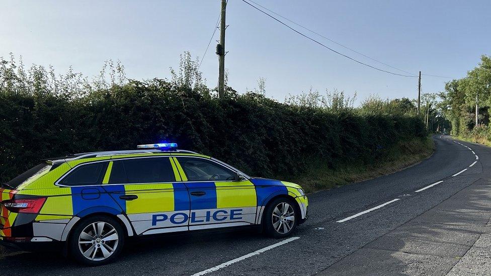 A police car parked on an empty road