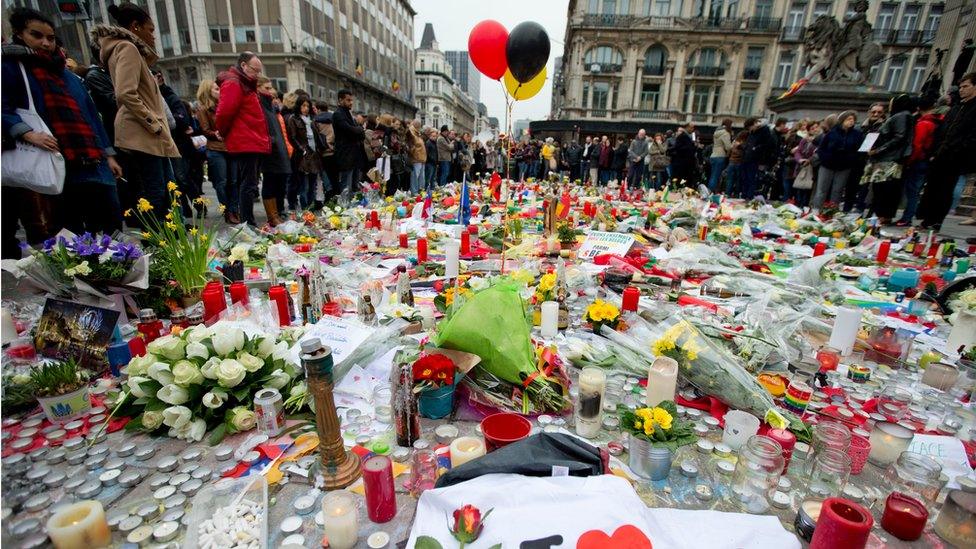 Three balloons in the colours of the Belgian flag fly as people mourn for the victims of the bombings at the Place de la Bourse in the centre of Brussels, Belgium, Thursday, March 24, 2016