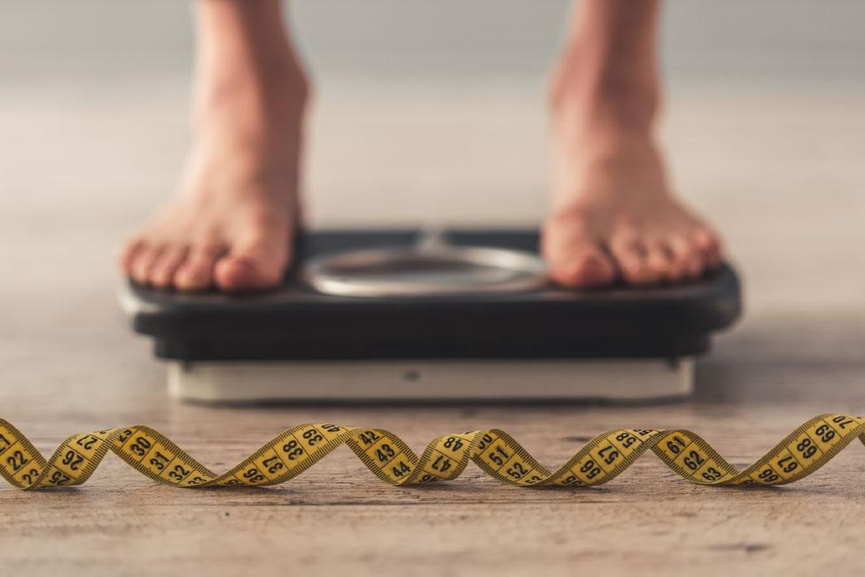 Feet on scales and tape measure