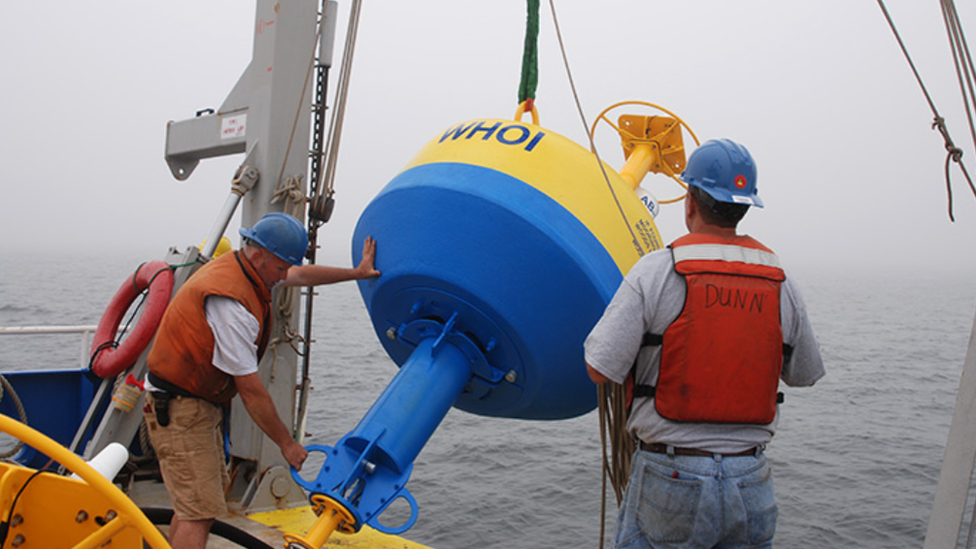 Woods Hole Oceanographic Institution placing robotic buoy in the sea