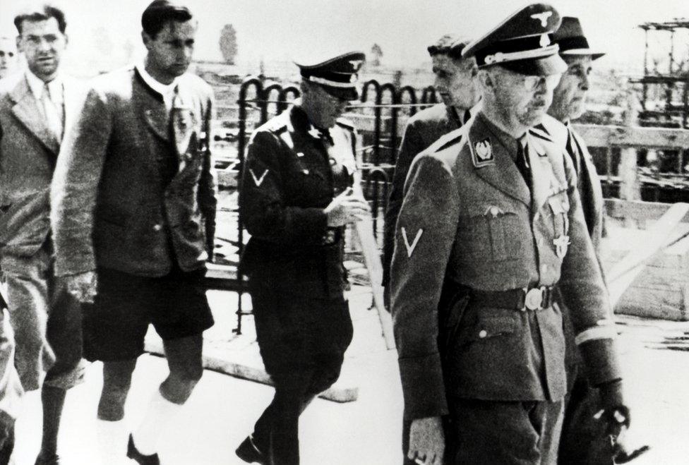 Heinrich Himmler (1900 - 1945, foreground right) and Chief Engineer Max Faust (far right) during Himmler's visit to the Monowitz-Buna plant (Auschwitz III) at Auschwitz, Poland, July 1942. (Photo by Galerie Bilderwelt/Getty Images)