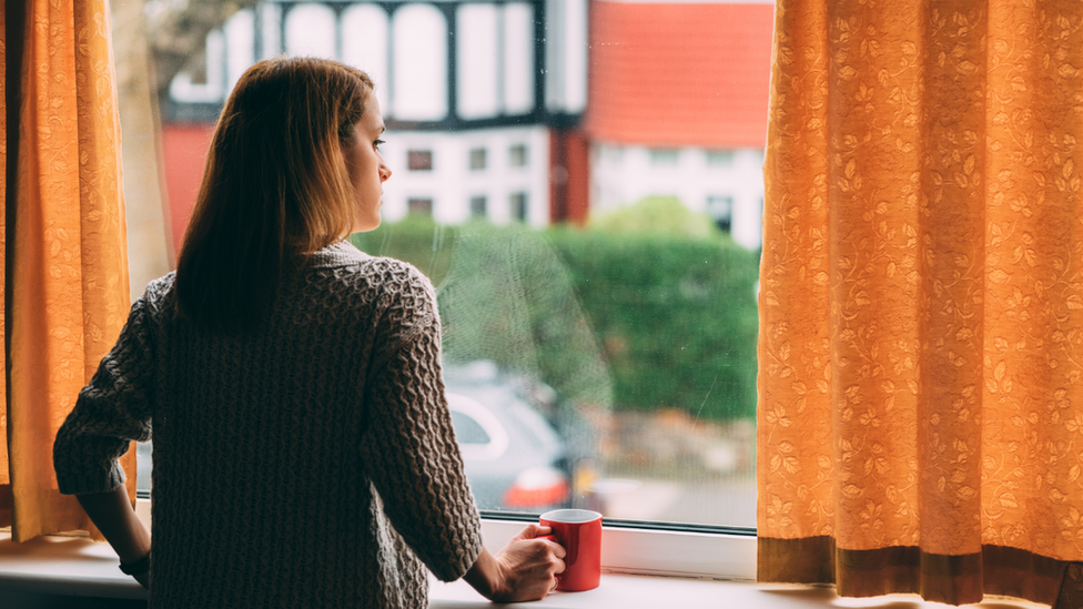 Woman watches from a window