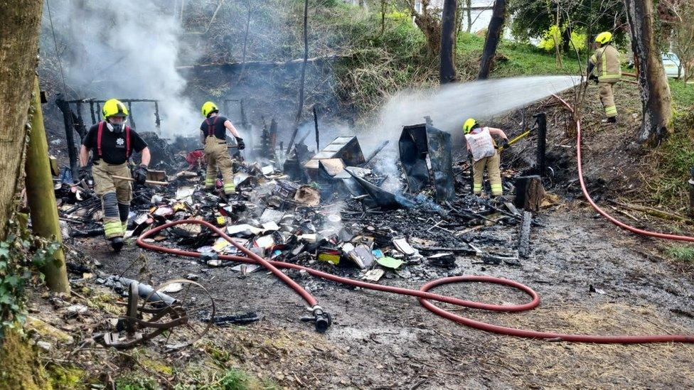 Fire officers with hoses spraying the burning remnants of Mr Grices collection of memorabilia