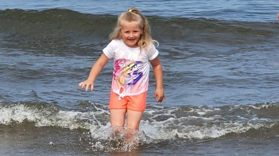 Five-year-old Maggie Black PLAYS IN THE sea.