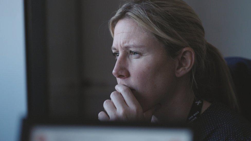 Detective Birkby looking at a computer screen on 24 Hours In Police Custody