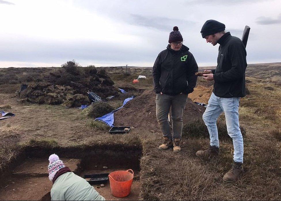 Volunteers examine a find at the site