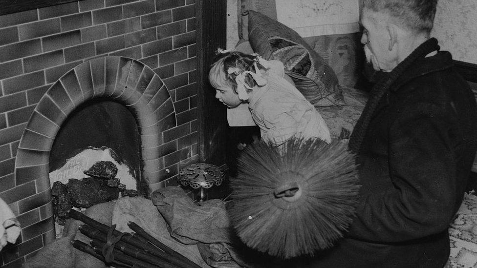 A chimney sweep at work with his brushes in 1937