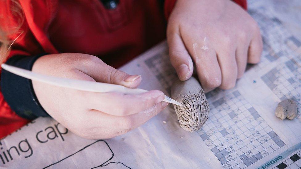 A child sculpting clay