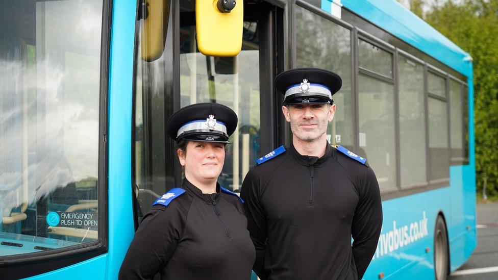 PCSOs Jessica and Matt next to a bus