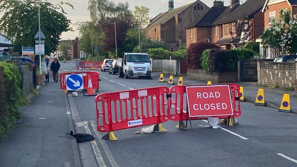 The road closed sign and traffic cones