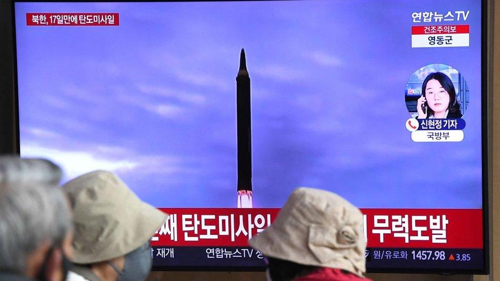 News broadcast with file footage of a North Korean missile test at a railway station in Seoul