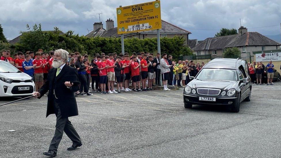 Crowds clapping as the hearse made its way past them