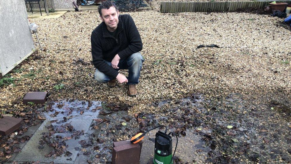 Philip Cox with a water pump in his back garden