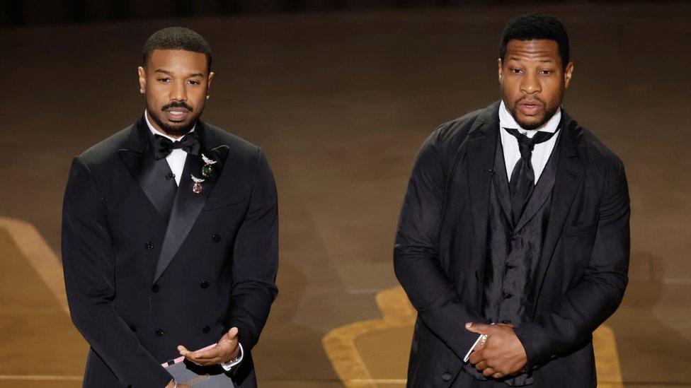 Michael B Jordan and Jonathan Majors at the Oscars presenting an award