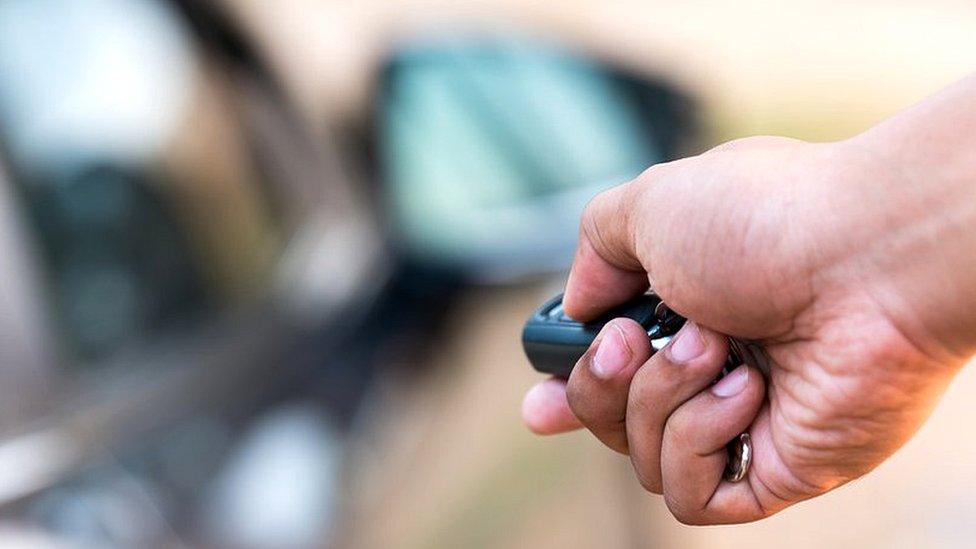 Man opening a car with a key fob fob.