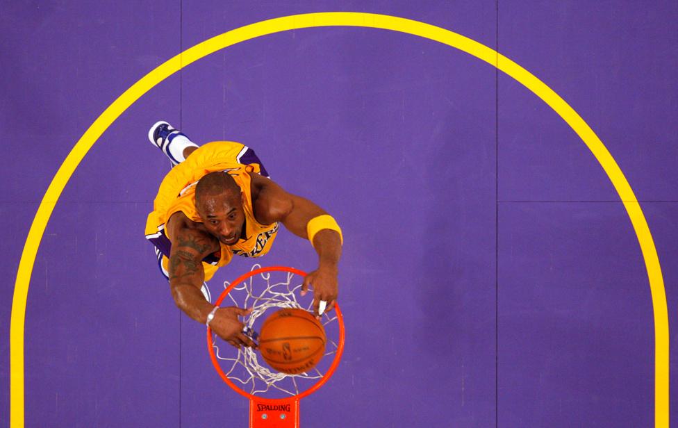 Kobe Bryant slam dunks against the Sacramento Kings during their NBA basketball game in Los Angeles in 2011.