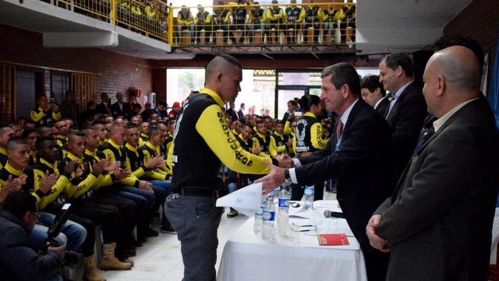 A member of the Revolutionary Armed Forces of Colombia (FARC) who receiving a disarmament certificate from the chief of the observers of the United Nations (UN) Mission in Colombia, General Javier Perez Aquino (R) in Facatativa, Colombia, 12 June 2017.