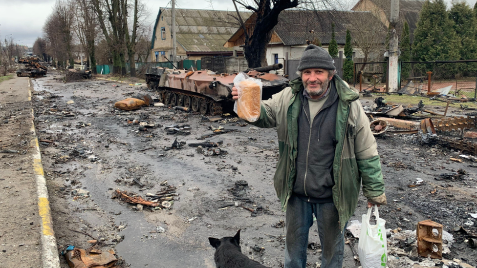 A local resident in Bucha with a loaf of Bread