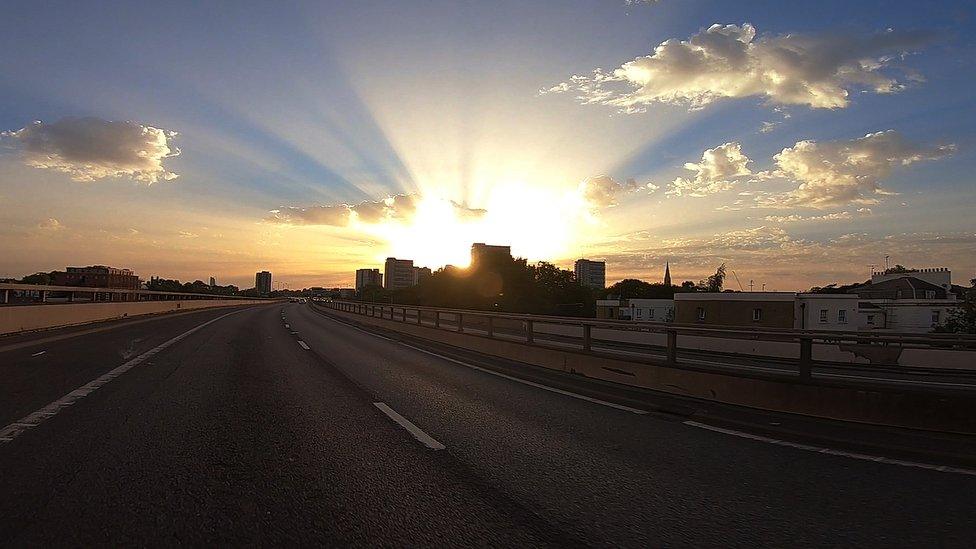 The sun over London, seen from a rooftop-level flyover