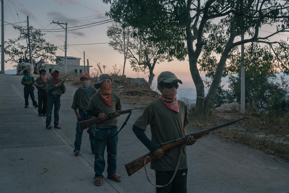 Alex (13), right, and other children stand during a Regional Co-ordinator of Community Authorities community police force gun training presentation in Ayahualtempa, Guerrero state, Mexico.