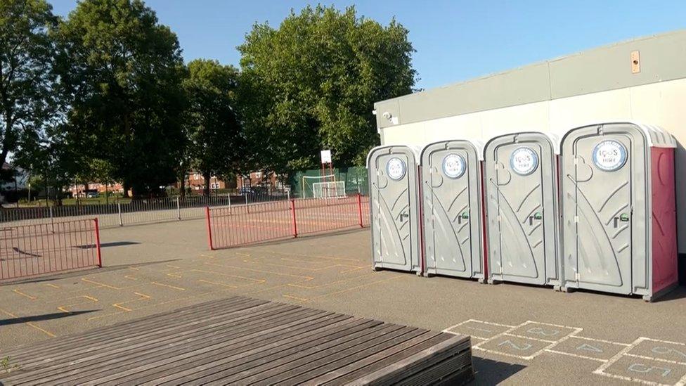 Porta loos on playground.