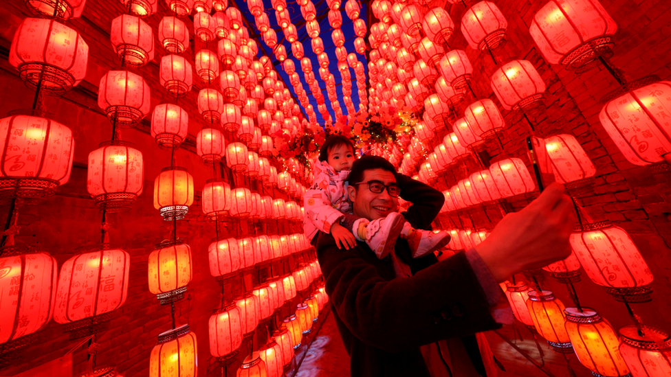 A man takes a picture of himself and a child during the Lantern Festival in Taiyuan, northern China. Photo: 26 February 2021