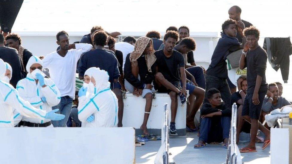 Migrants wait to disembark Italy's coastguard vessel at the port of Catania. Photo: August 2018