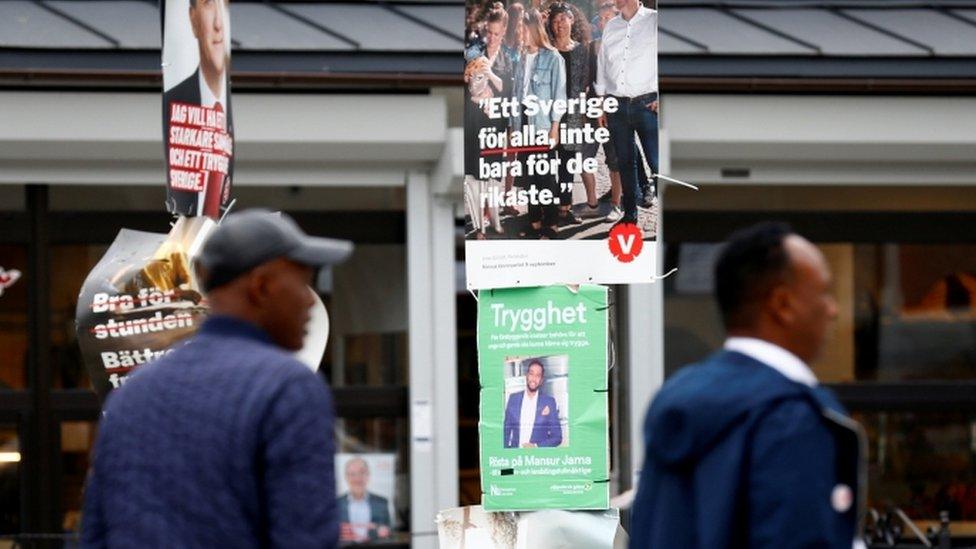 People walk past election campaign posters in Stockholm, 7 September