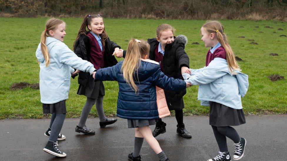 A group of children play outdoors at Glan-Yr-Afon primary school in Cardiff