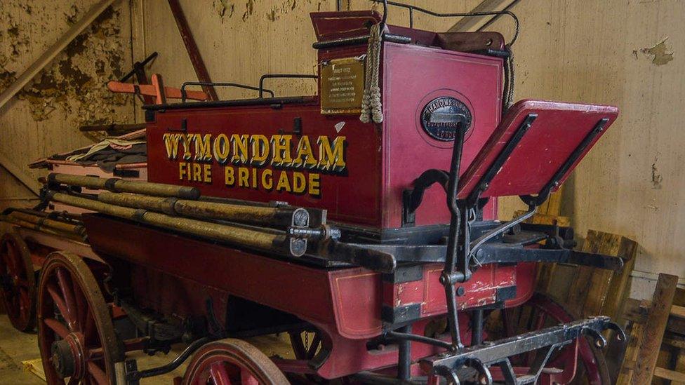 Horse-drawn fire engine at Norfolk Fire Museum with "Wymondham fire brigade" on the side