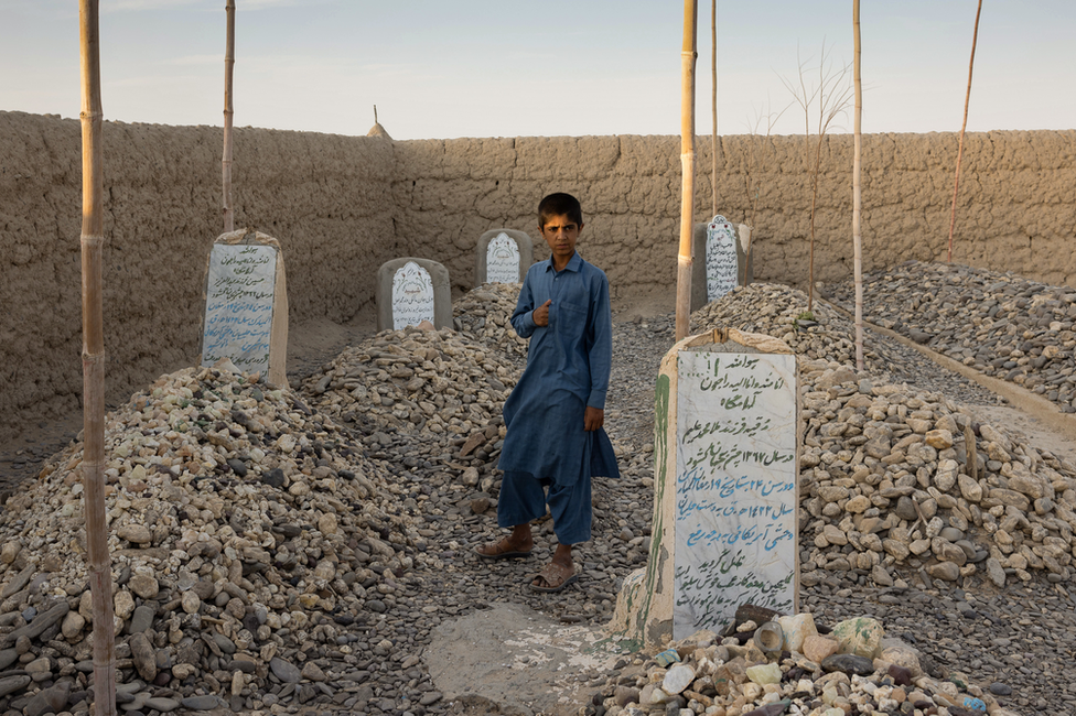 Imran stands by his parents' graves. "I wish our mother and father were with us today," he said. Image: Julian Busch/BBC