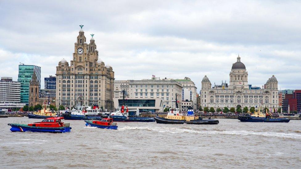 River tugs perform Fleur De Lis, (spraying of water from their fire cannons) as vessels gather on the River Mersey in Liverpool