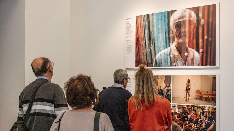 Attendees of the World Press Photo exhibition in Budapest, Hungary, view the work of Hannah Reyes Morales