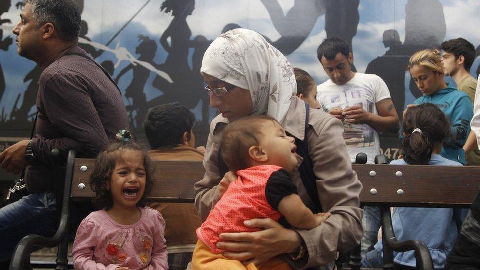 A child cries as hundreds of people tried to board a train to take them out of Hungary