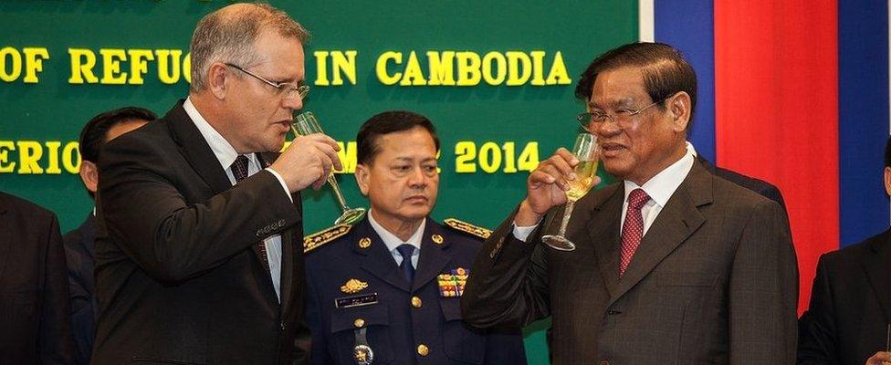 Australian Immigration Minister Scott Morrison and Cambodian Interior Minister Sar Kheng celebrate signing the deal with champagne (Sept 2014)