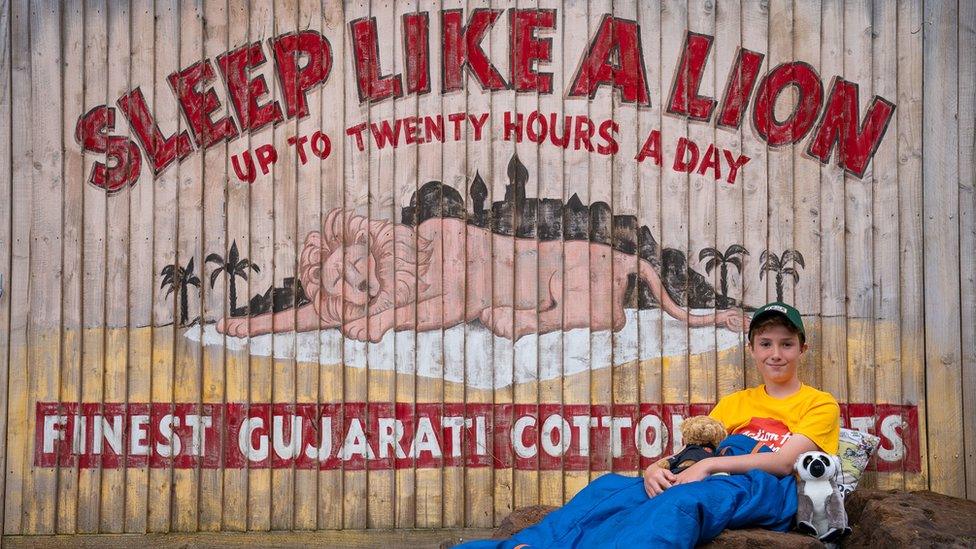 Max Woosey in front of sleeping lion sign