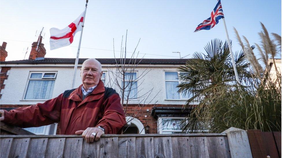 Ian Durrant with the Union Flag and the cross of St George in front of his house in Lincoln