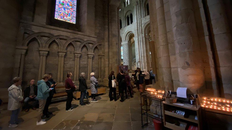 A queue of people inside the cathedral